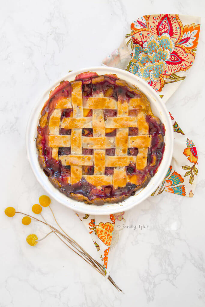 Top view of a blueberry peach pie baked and bubbly with a lattice top