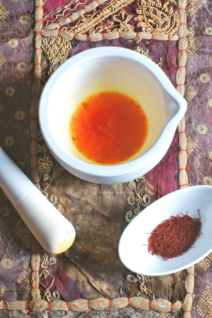 Saffron crushed in a mortar and pestle and steeped in water