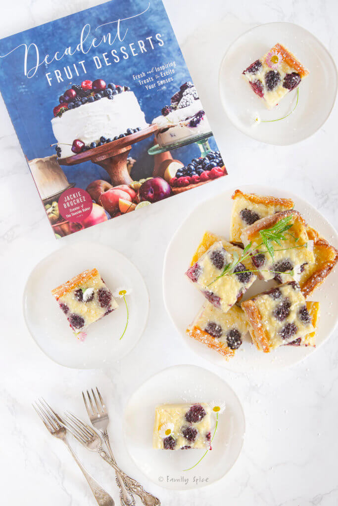 Custard bard cut into squares on small white plates with Decadent Fruit Desserts cookbook next to it