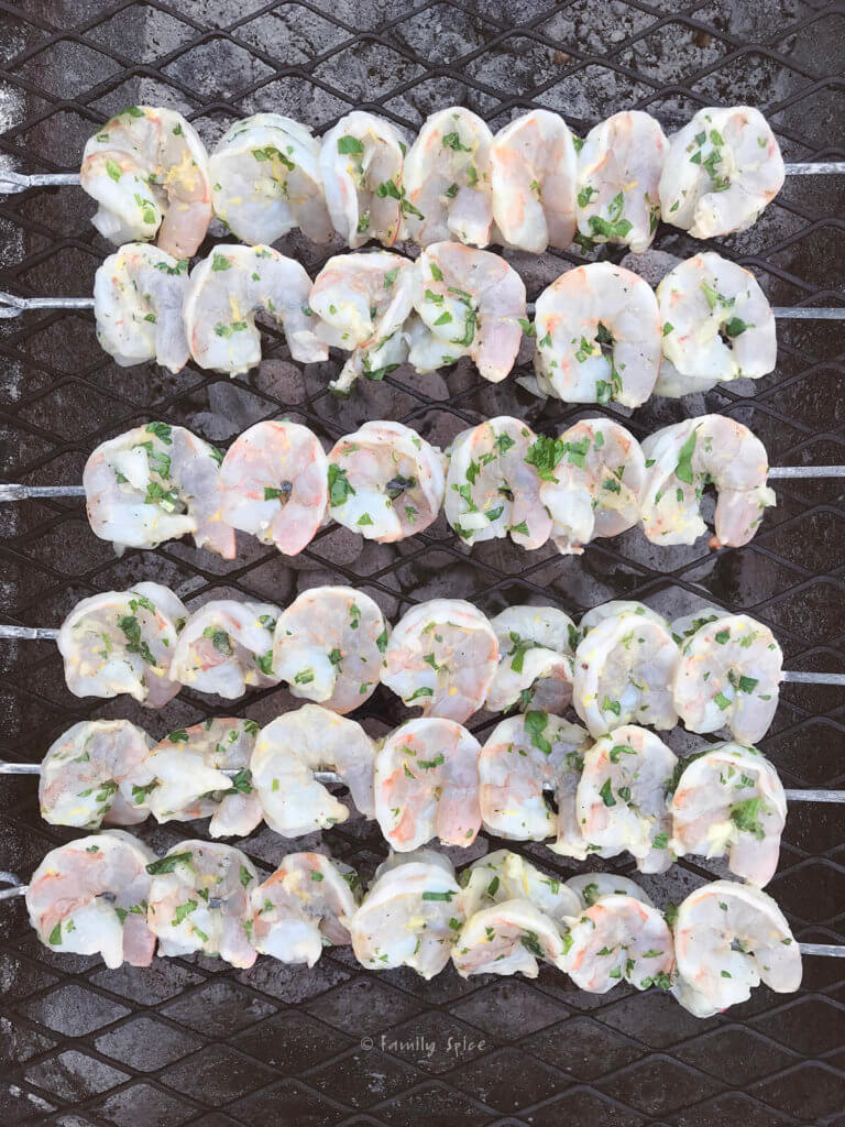 Skewers of marinated shrimp placed on grill