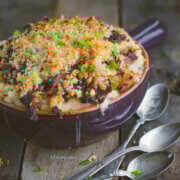 Closeup of a purple ceramic dish with pulled pork mac and cheese in it