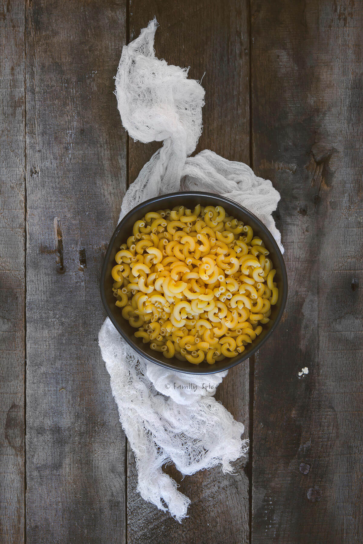 Top view of a bowl with uncooked macaroni in it