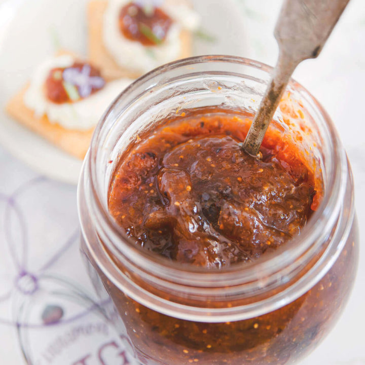 Top view of a jar of fig jam with a spoon in it