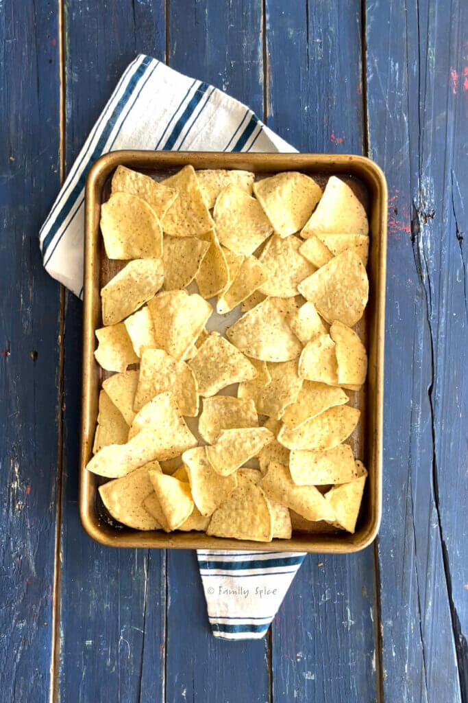 Top view of a baking sheet with tortilla chips on it