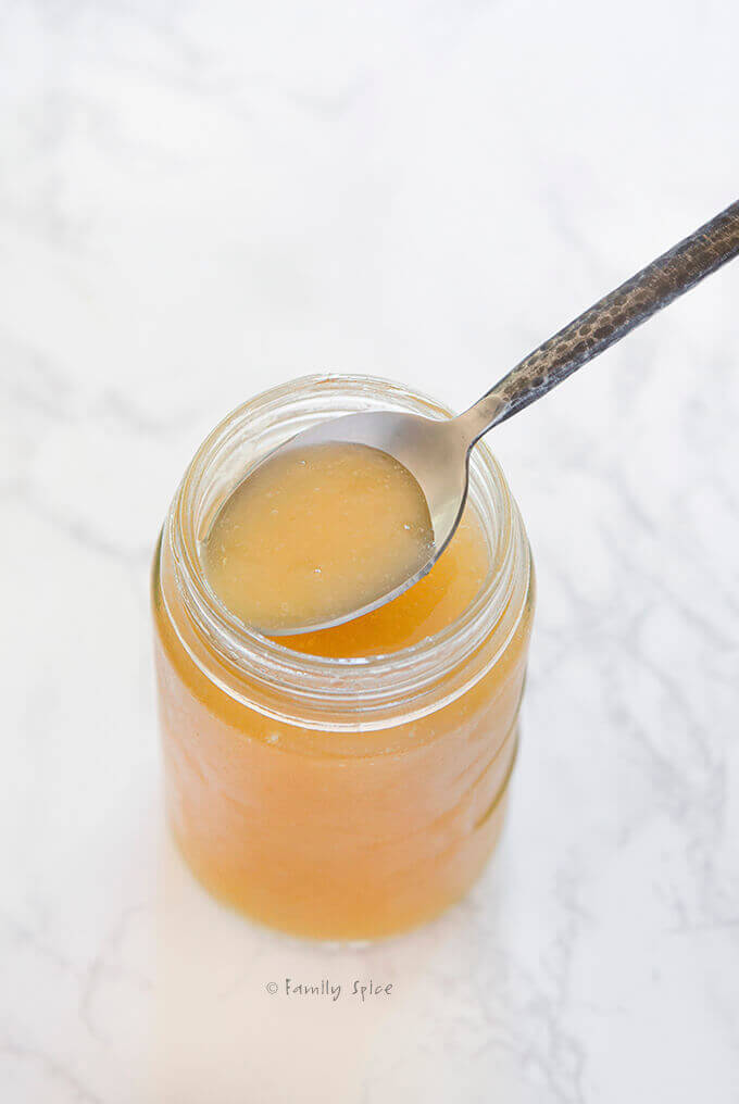 A spoon scooping out some jelly chicken bone broth by FamilySpice.com