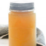 A side view of a mason jar filled with instant pot bone broth by FamilySpice.com