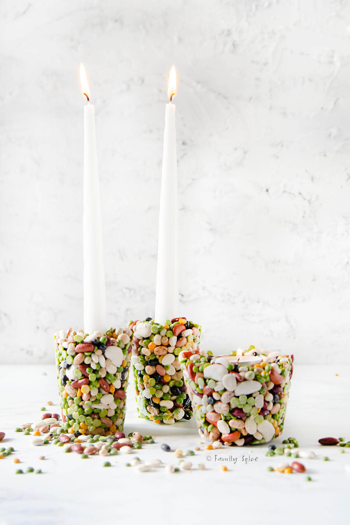 DIY candle holders made with beans on a white background