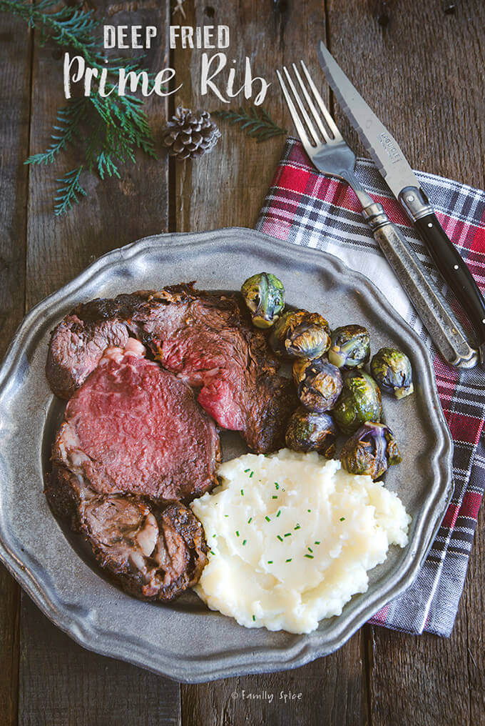 A plate of a slice of deep fried prime rib with mashed potatoes and Brussels sprouts by FamilySpice.com