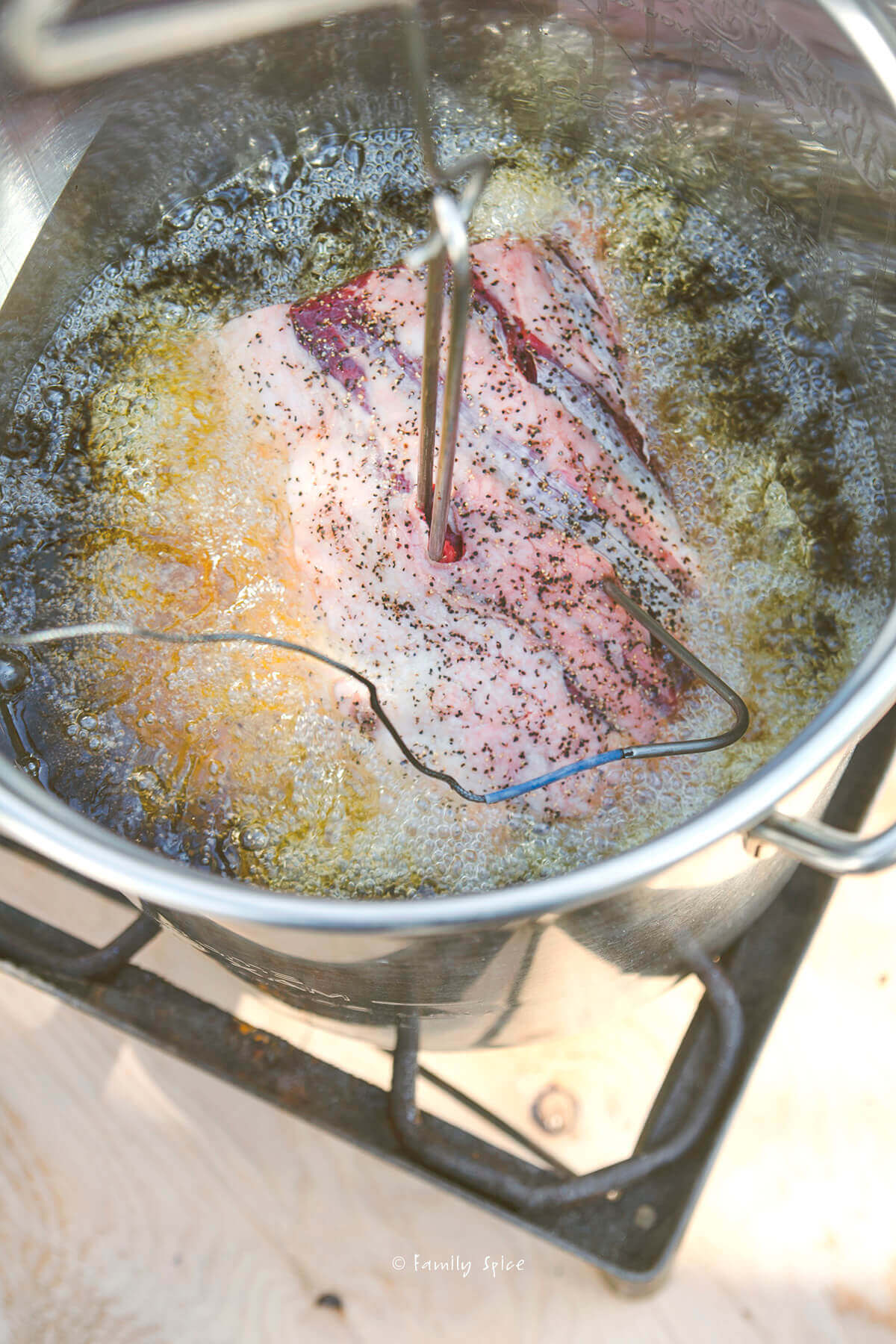 Lowering a rib roast into a deep fryer