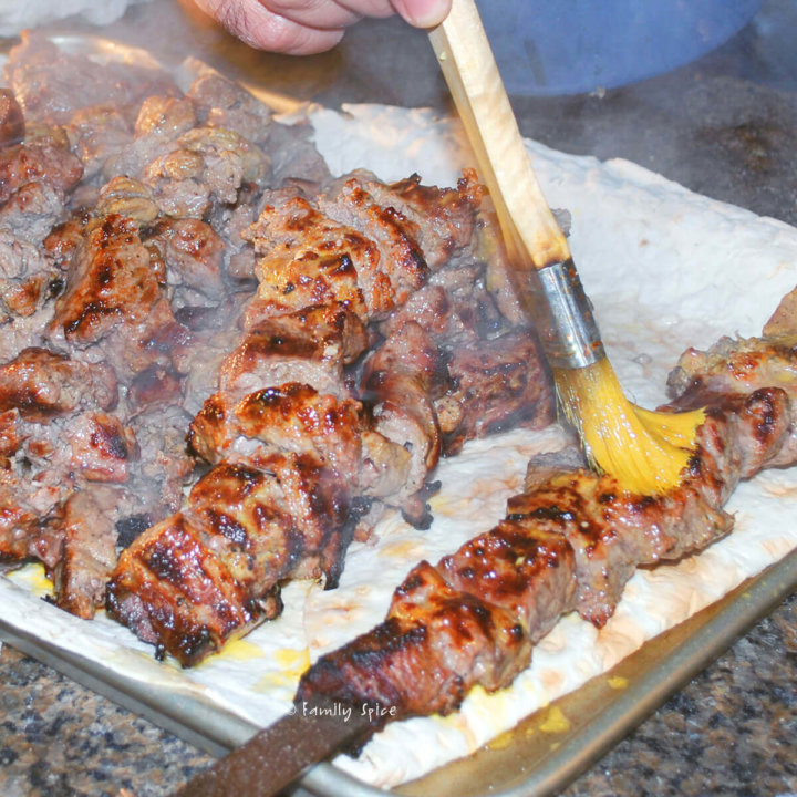 Basting grilled kabob barg with butter by FamilySpice.com