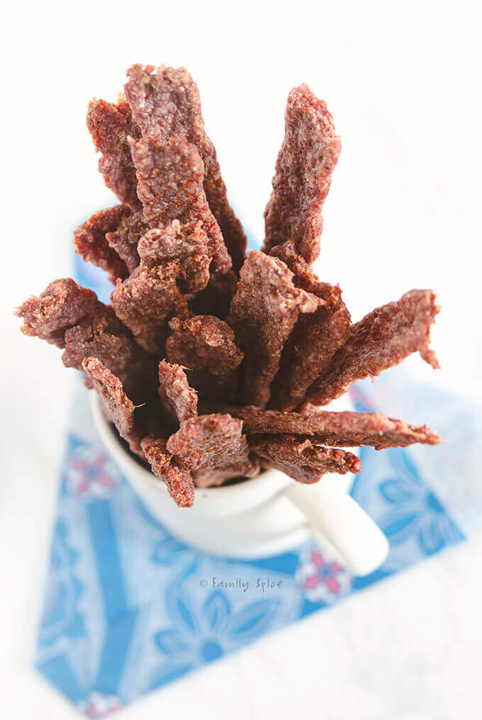 Top view of a white ceramic mug filled with ground beef jerky sticks by FamilySpice.com
