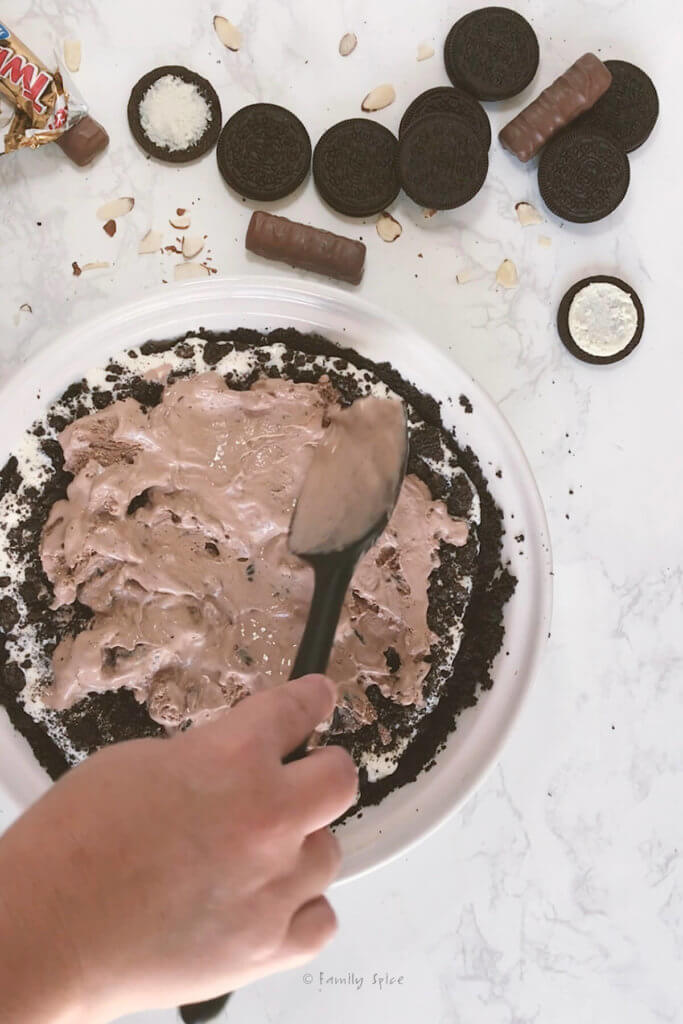 Spreading chocolate ice cream to make a mud pie