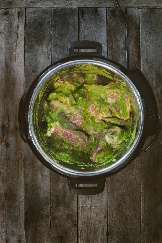 Chili verde sauce mixed in with chunks of raw pork in an instant pot