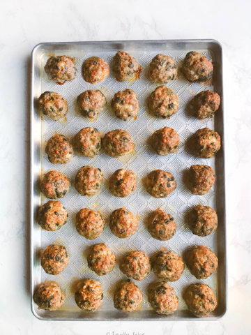 A baking sheet filled with baked meatballs