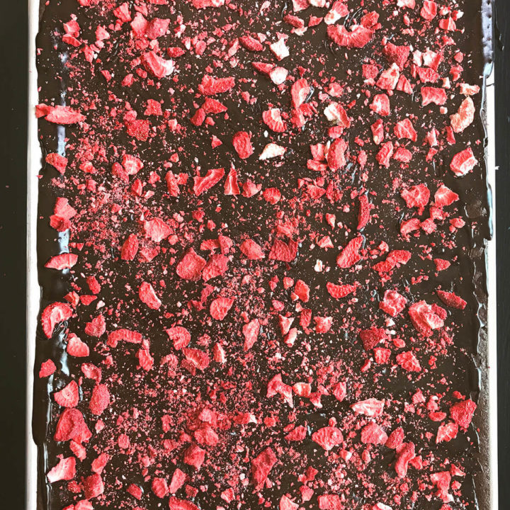 An entire sheet pan chocolate cake topped with freeze dried strawberries
