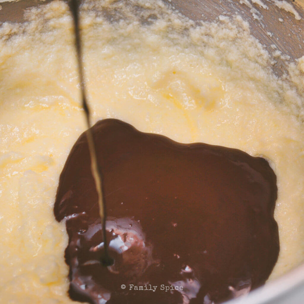 Adding melted chocolate to butter mixture to make brownies