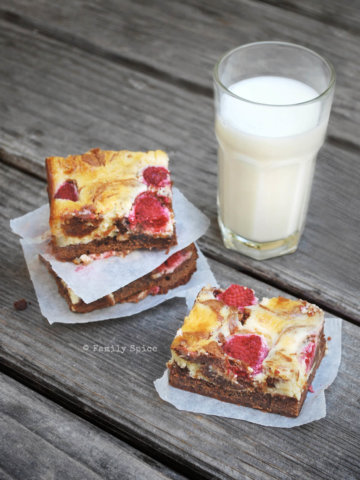 Slices of raspberry cheesecake brownies with a glass of milk