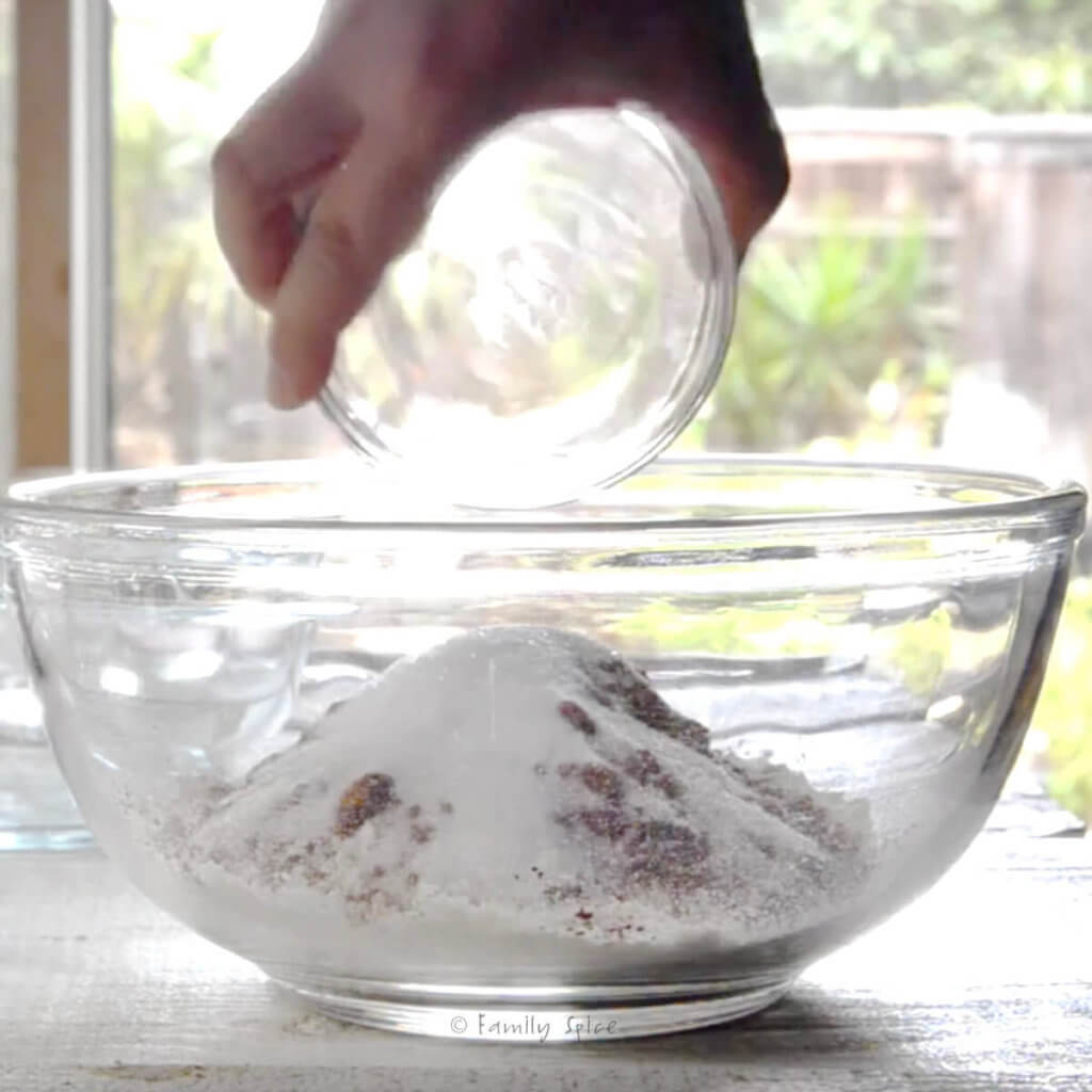 Adding dry ingredients into a glass bowl for chocolate pie dough