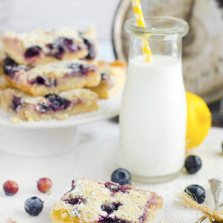 Closeup of a blueberry lemon bars with a glass bottle of milk