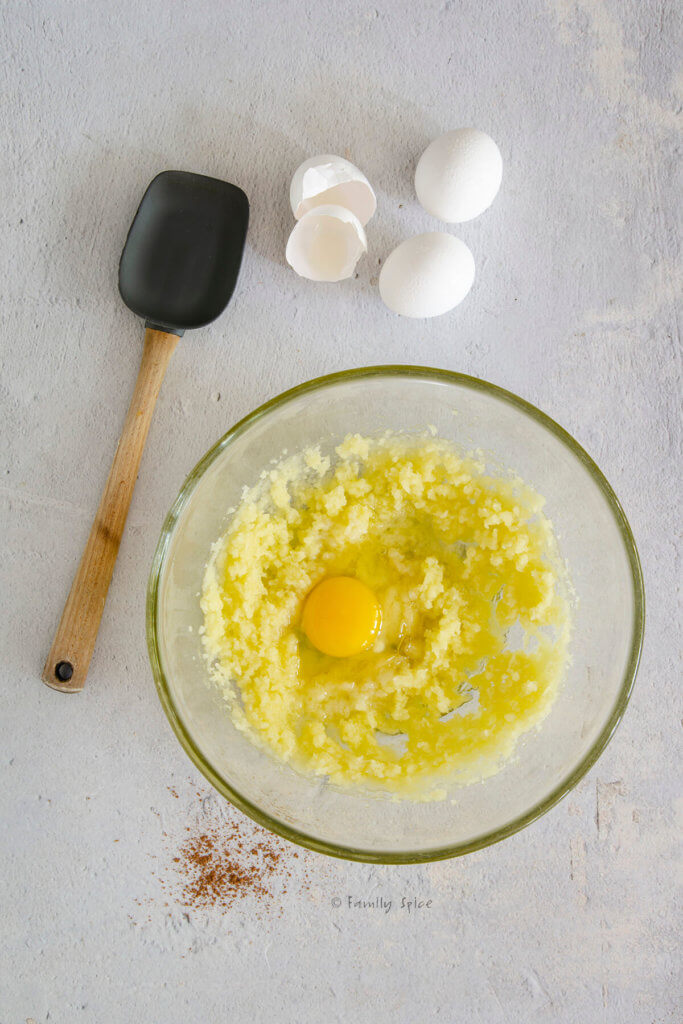 Egg added to cake batter in glass mixing bowl
