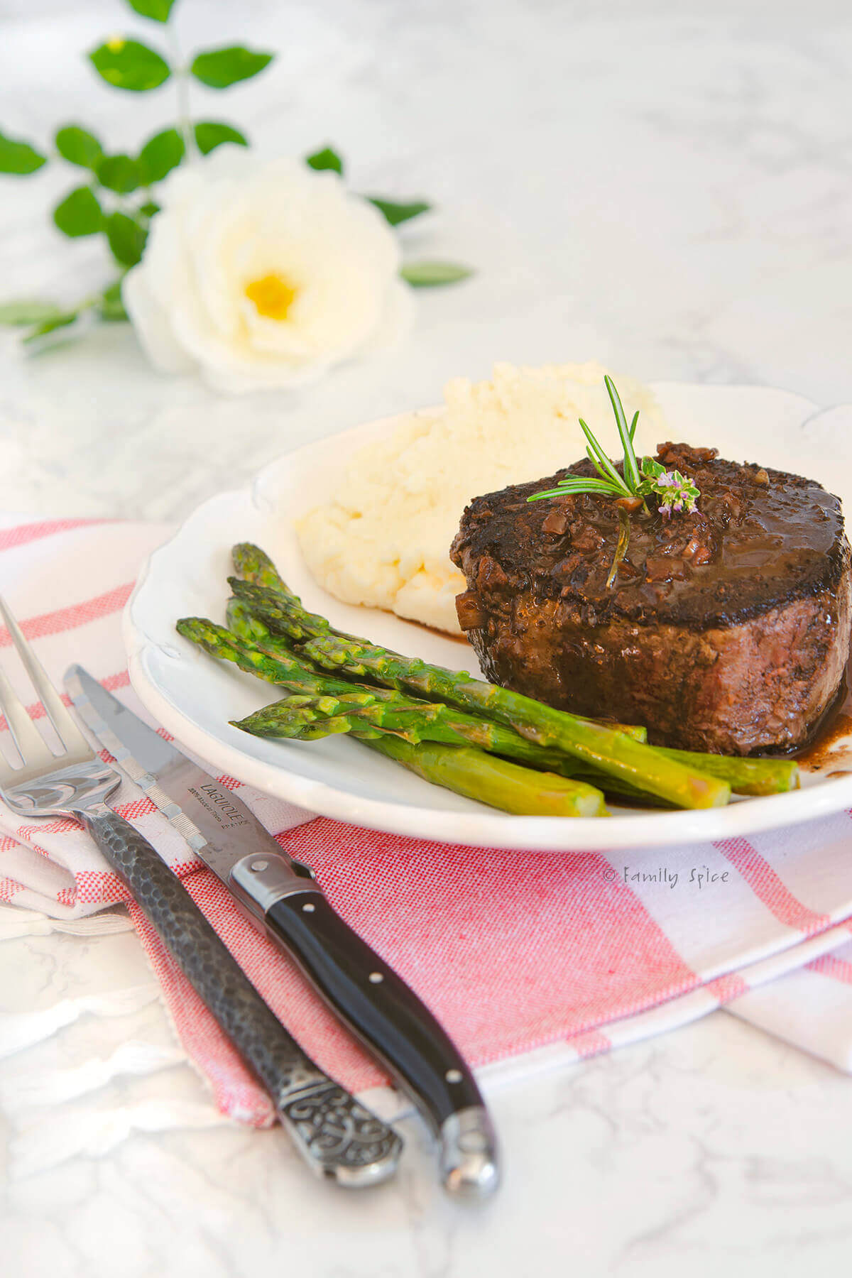 A plate with filet mignon, asparagus and mashed potatoes
