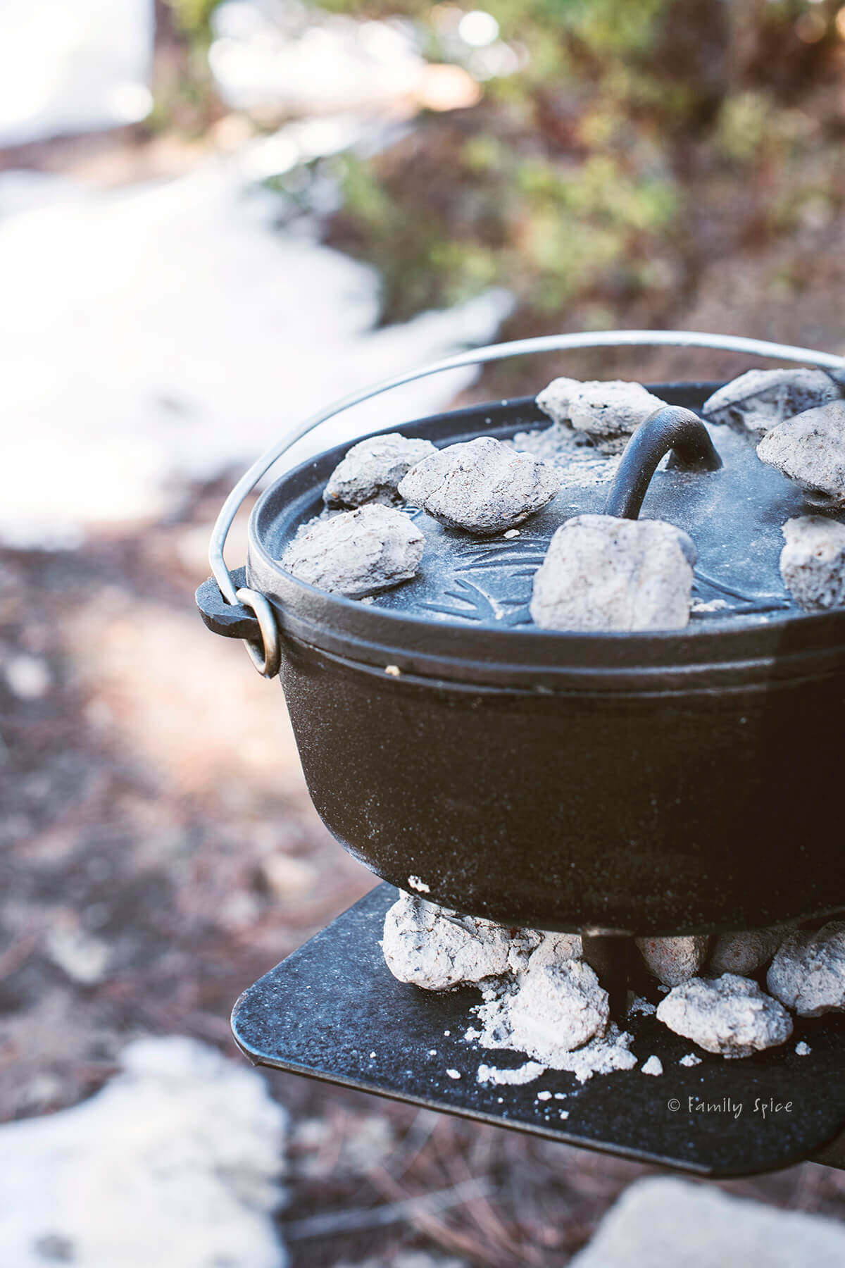 Dutch oven cooking with coals in forest with snow