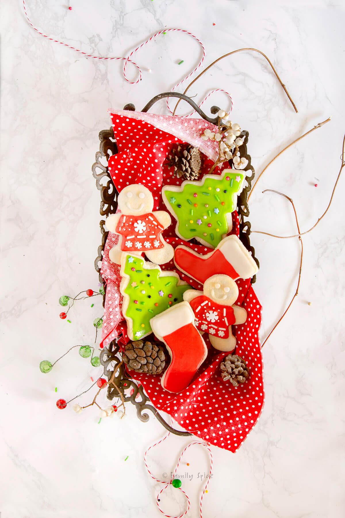 A metal tray with decorated Christmas sugar cookies in it