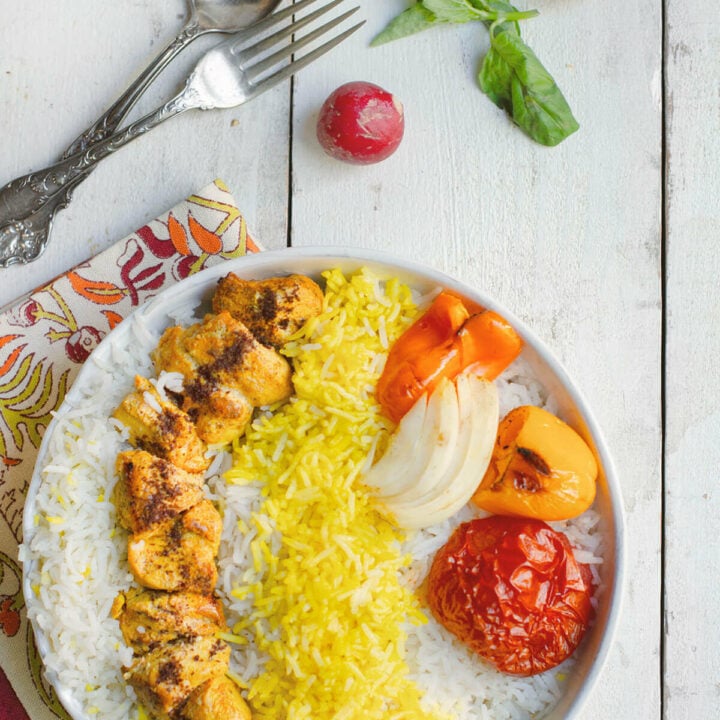 Closer view Persian chicken kebab with basmati rice, grilled tomato, onion and peppers