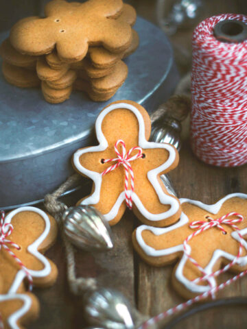 Closeup of a gingerbread man cookie with baker's twine tied around it