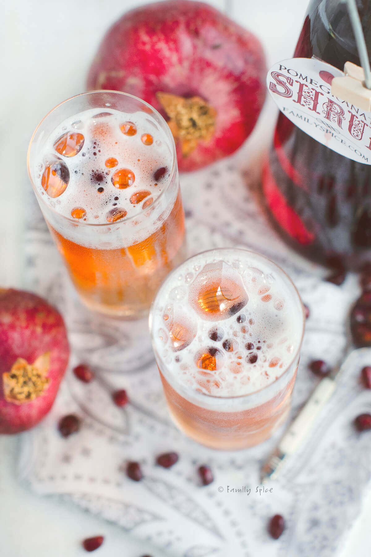 Top view of two glasses of bubbly champagne with pomegranate