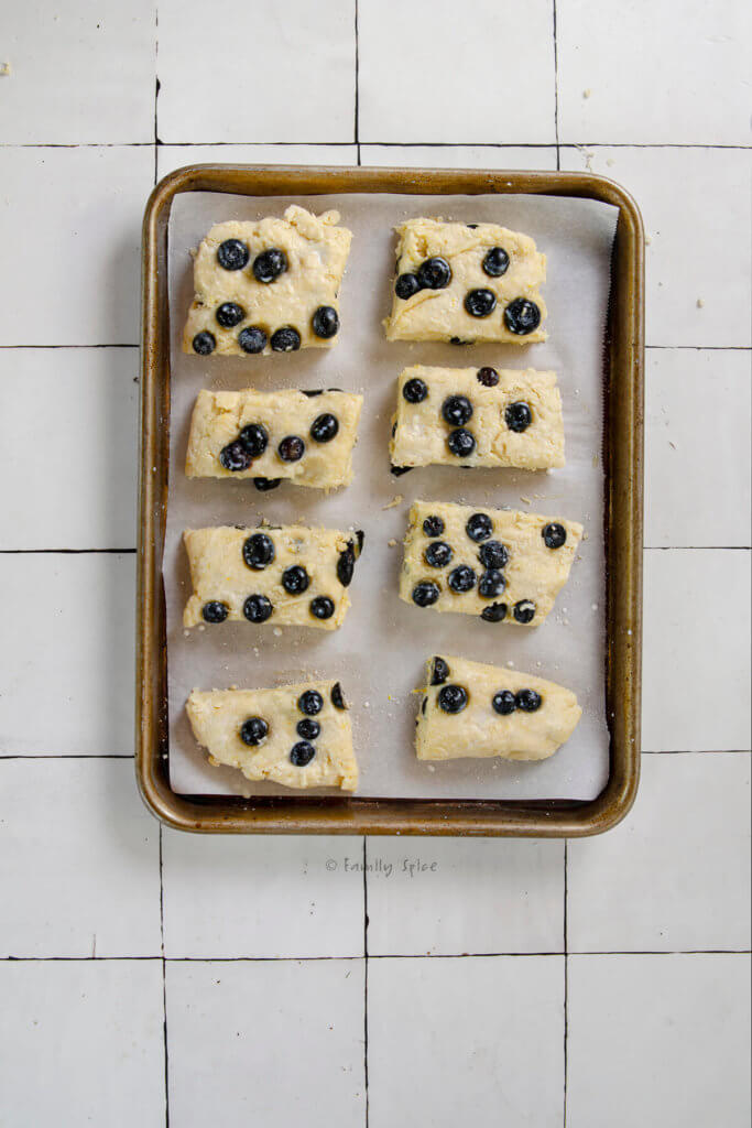 Raw blueberry sour cream scones on a small baking sheet ready to be baked