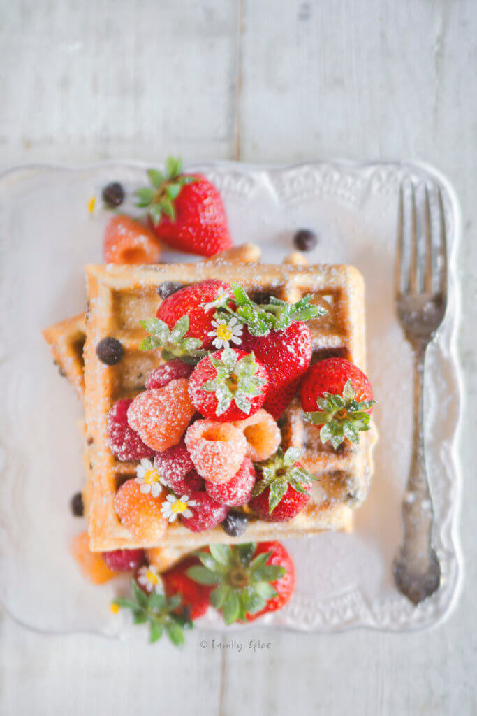 Top view of a stack of chocolate chip waffles topped with fresh berries