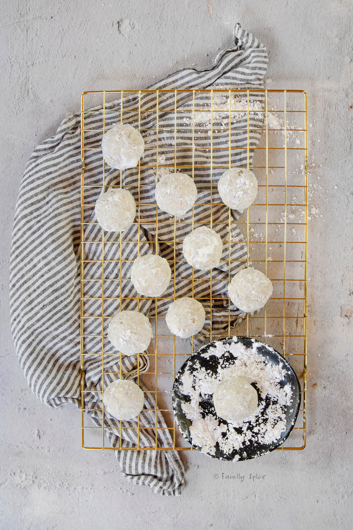 Sand tart cookies covered in powdered sugar on a cooling rack