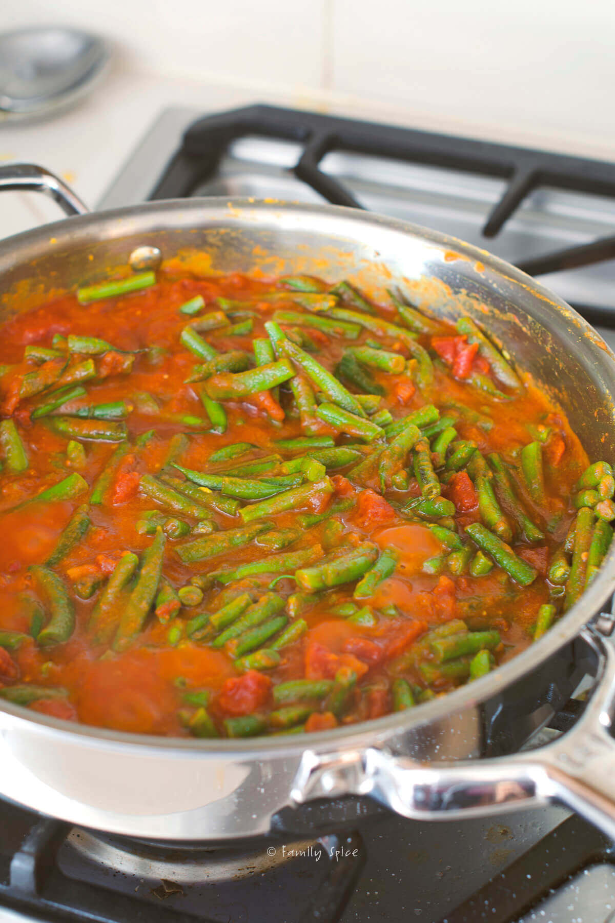 A stainless pan with Persian green bean stew (khoresht loobia sabz) in it