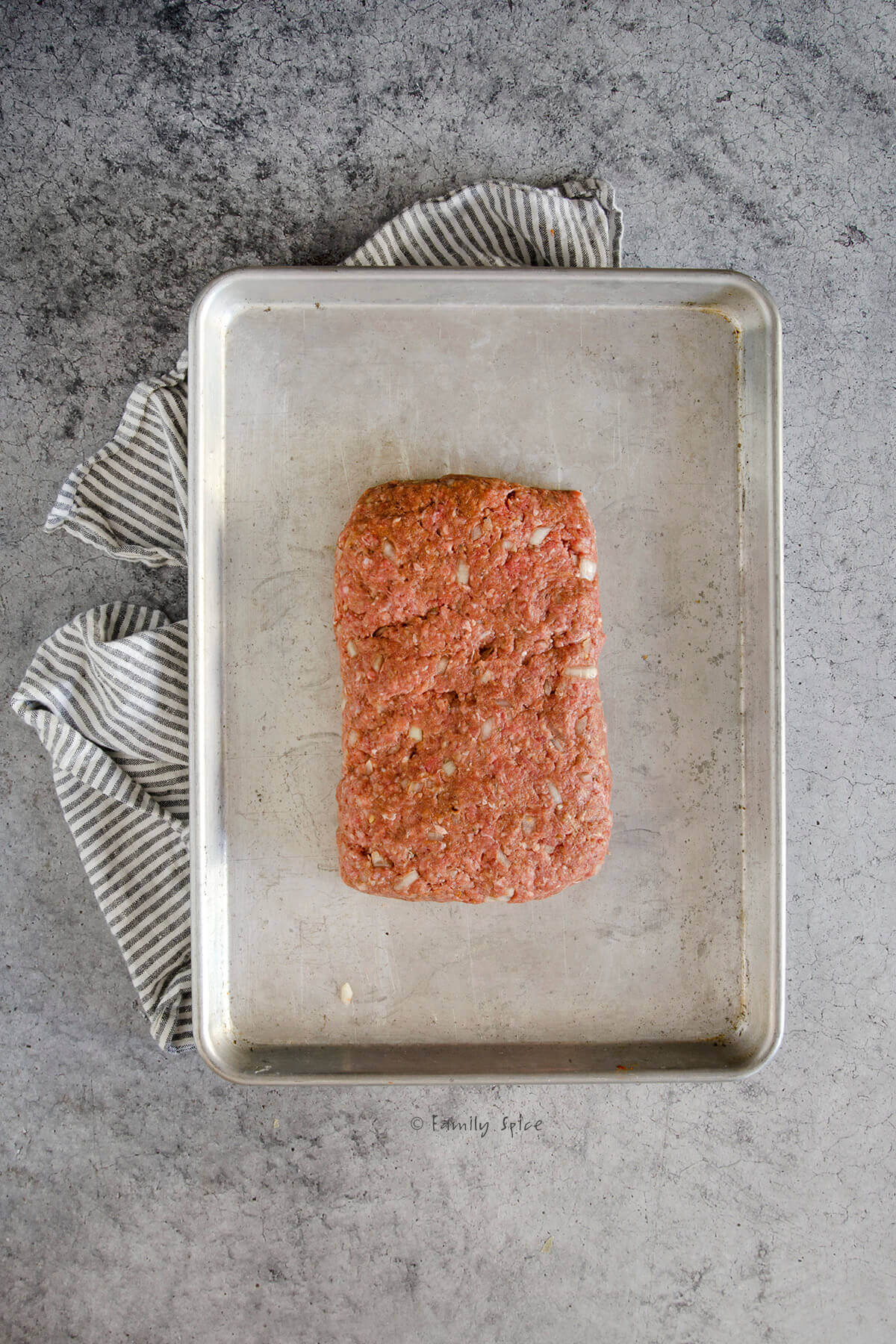 Meatloaf mixture formed into a rectangle on a baking sheet