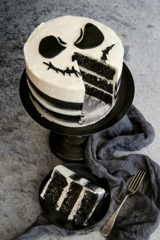 ¾ view of a Jack Skellington cake with a slice cut out and the cake slice next to it