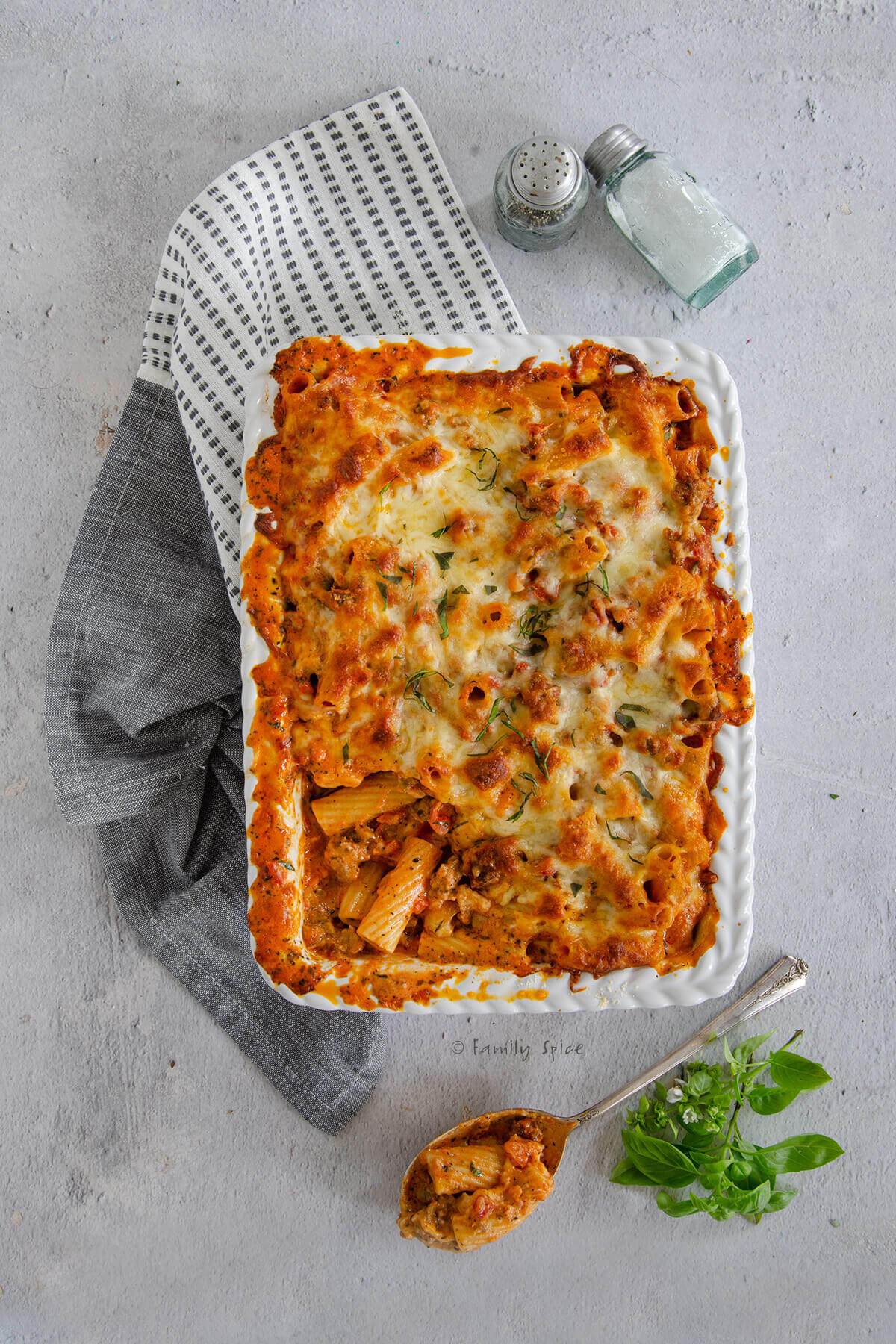 Top view of a casserole dish with bolognese pasta bake and a scoop taken out