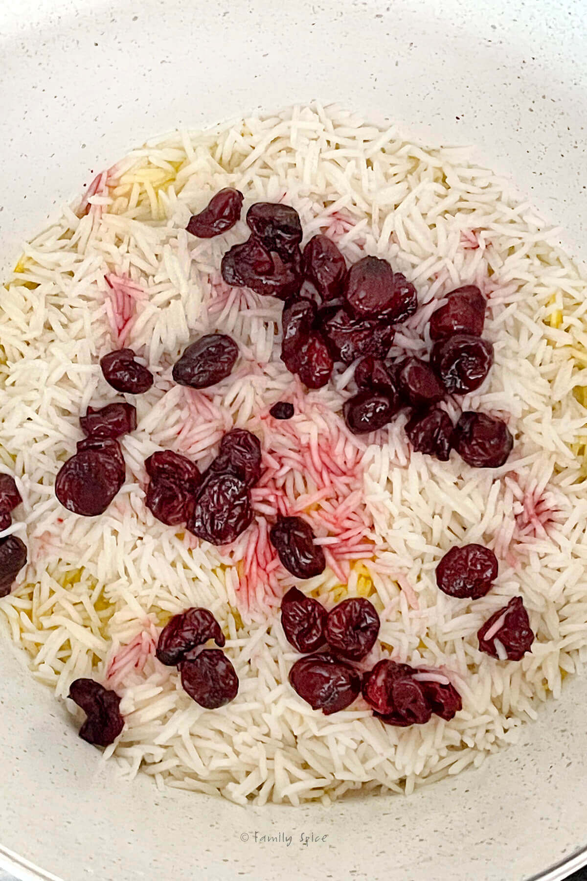 Sour cherries and syrup layered with basmati rice in a pot