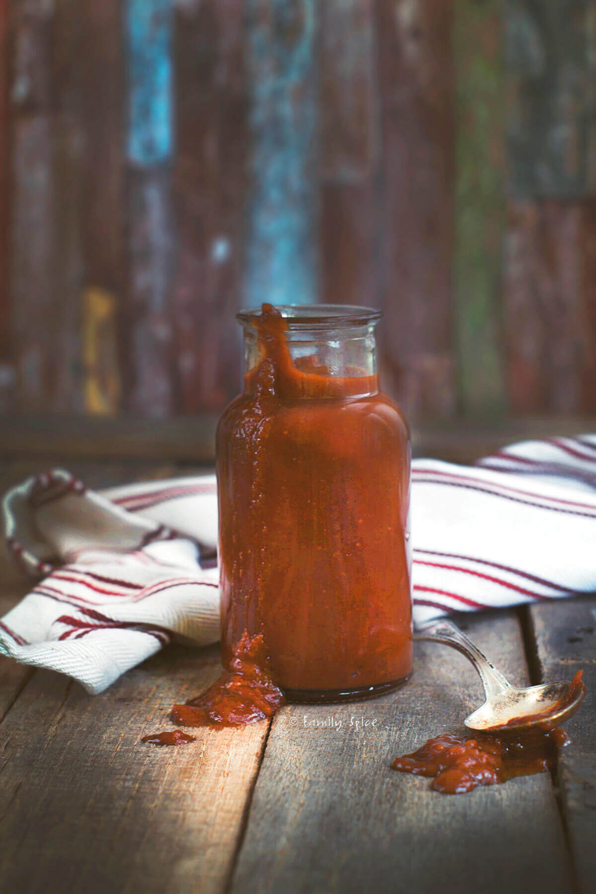 A rustic bottle of homemade whiskey barbecue sauce on a dark background
