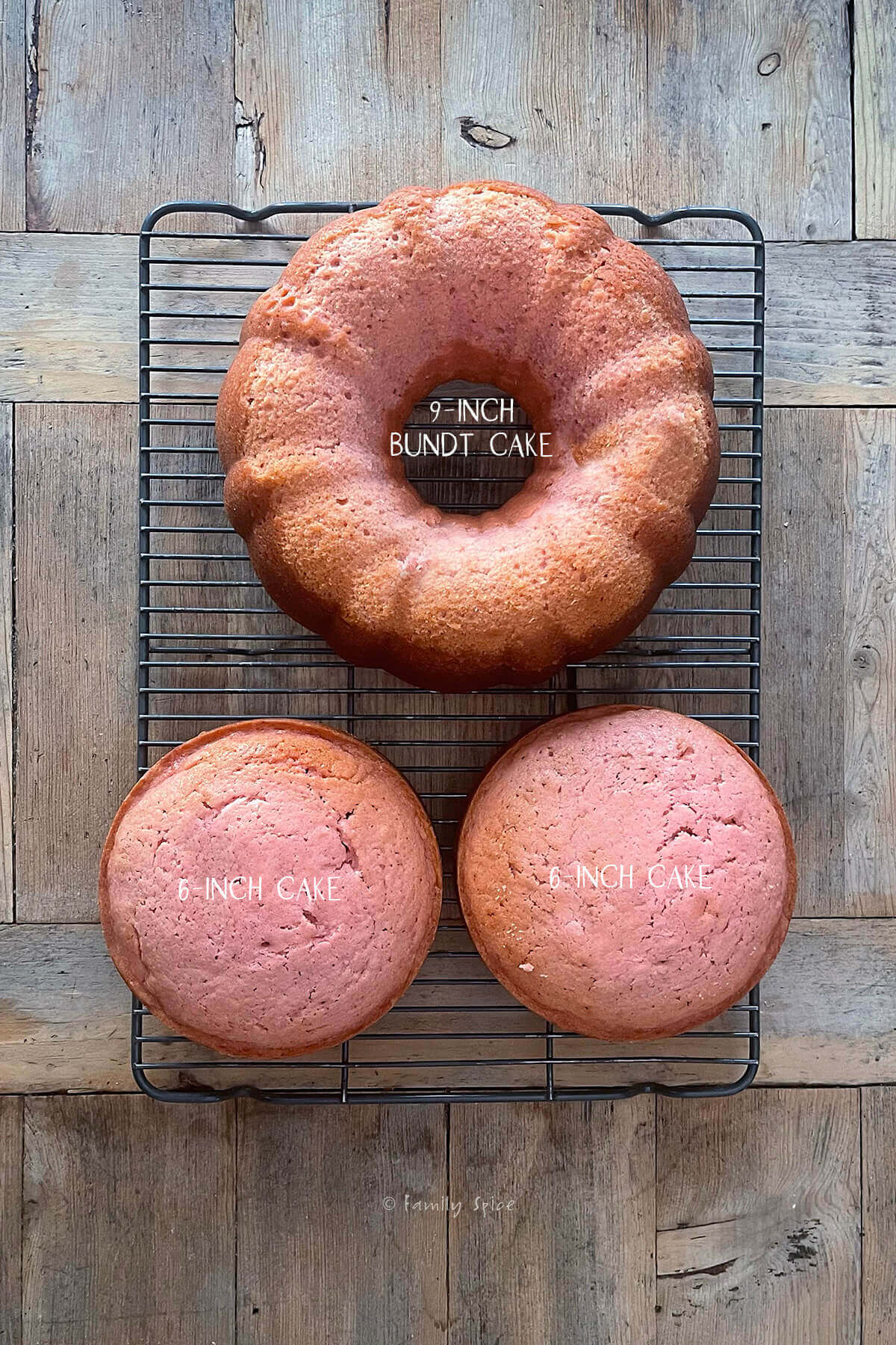 Top view of a pink strawberry bundt cake and two 6-inch strawberry cakes on a cooling rack on a wood table labeled and needed to make a barbie cake