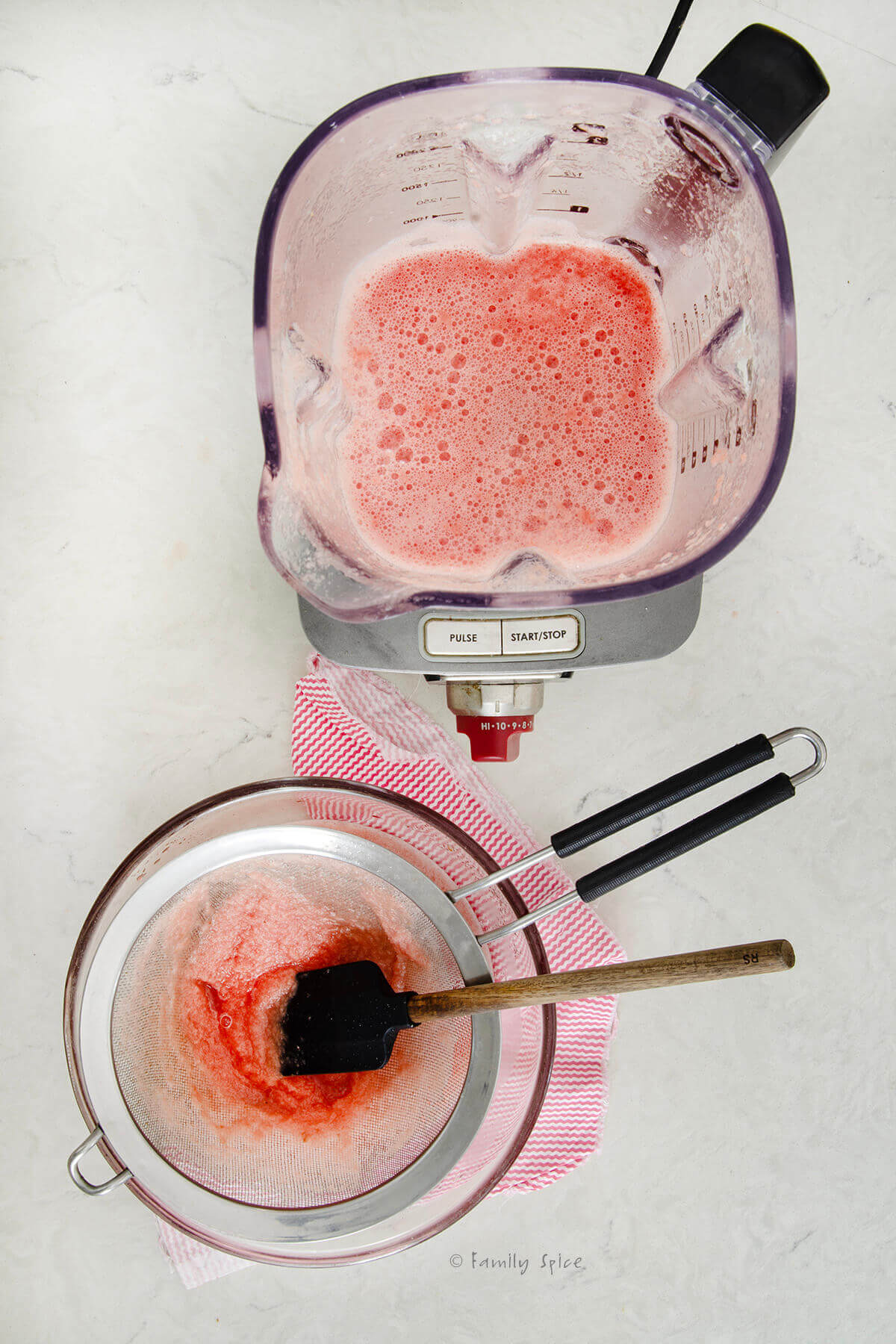 A blender filled with watermelon juice next to a bowl with a strainer on top straining blended watermelon