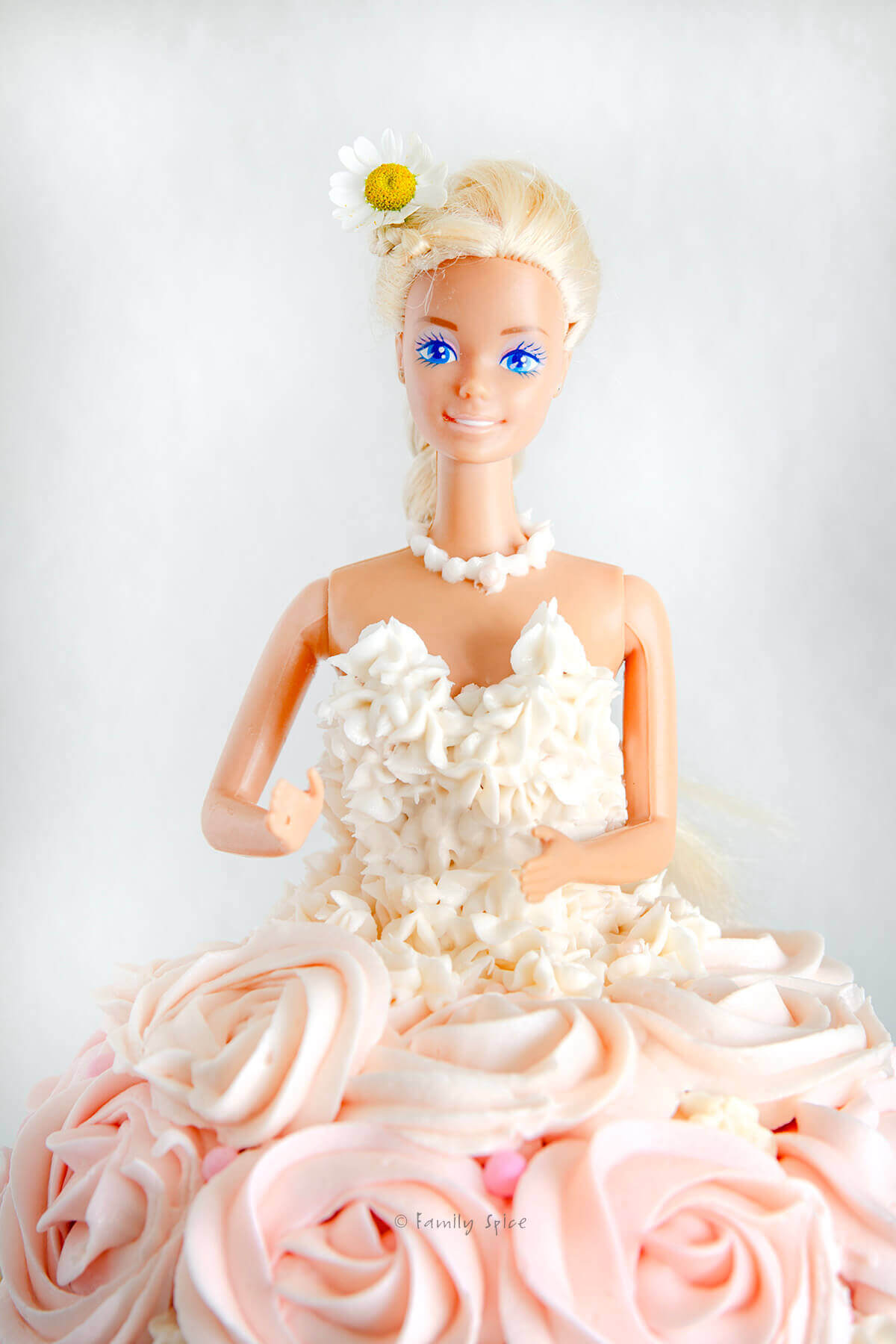 Closeup of barbie doll on a barbie themed cake