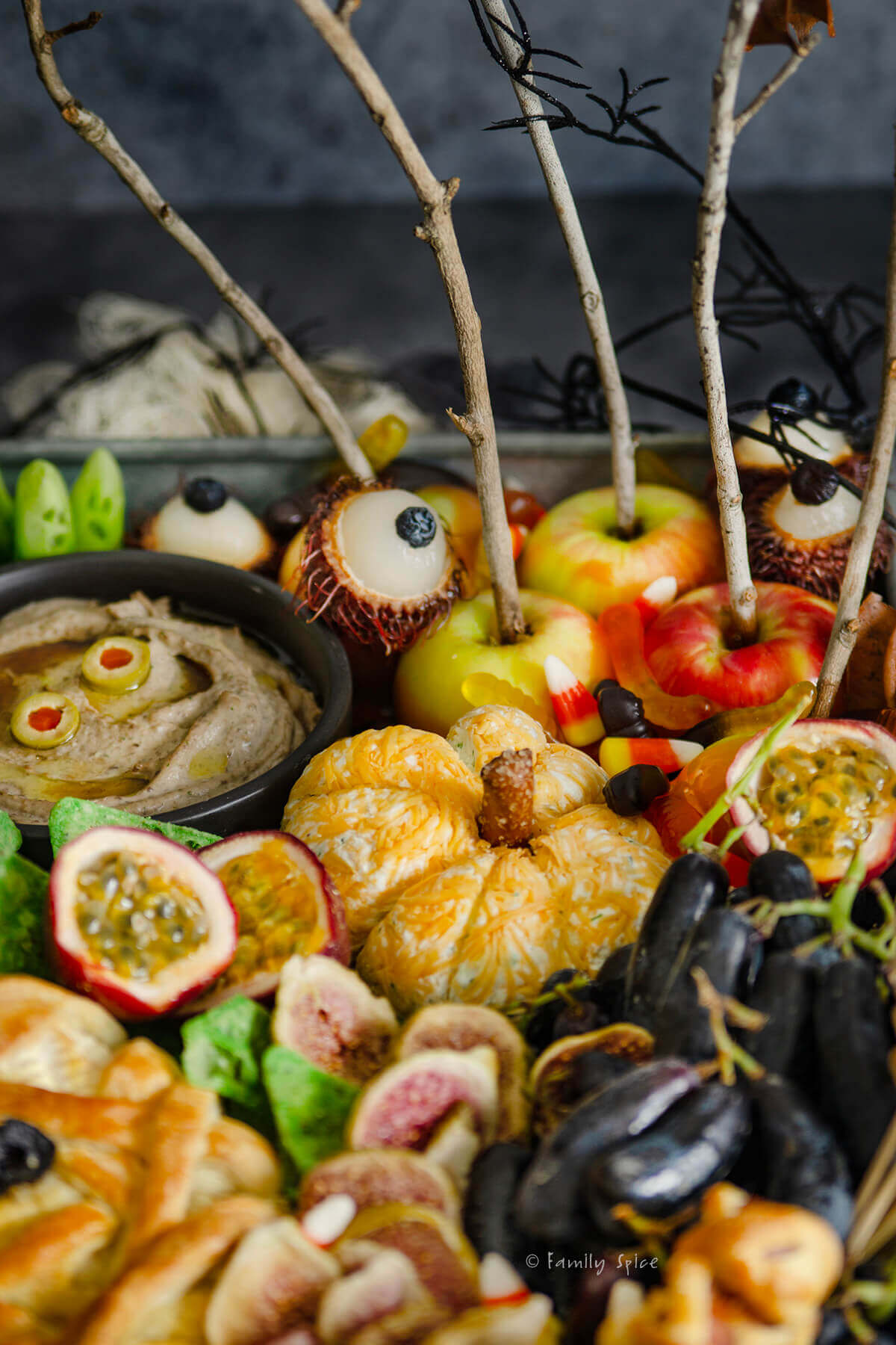 Closeup of pumpkin cheese ball surrounded by other items on a halloween charcuterie board