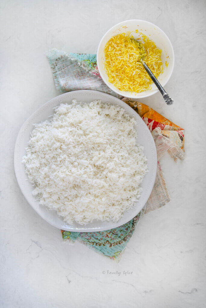 Top view of a round platter with Persian rice with a small bowl with saffron rice in it