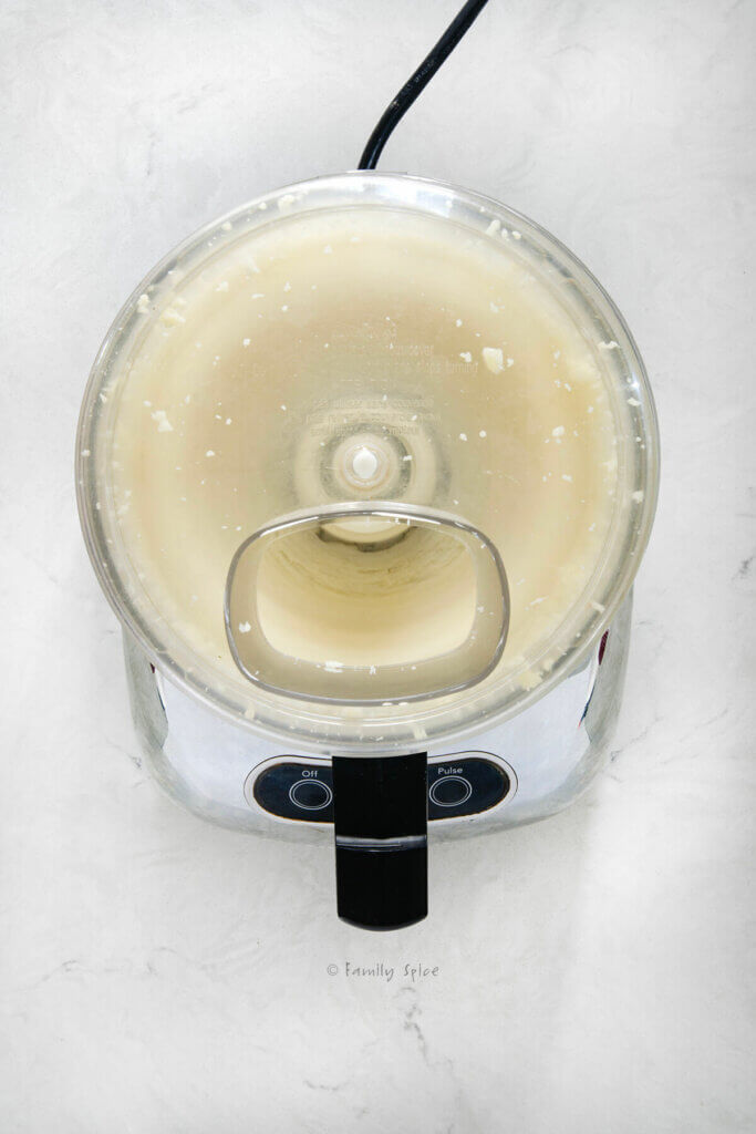 Top view of a food processor whirling with brie getting whipped in it
