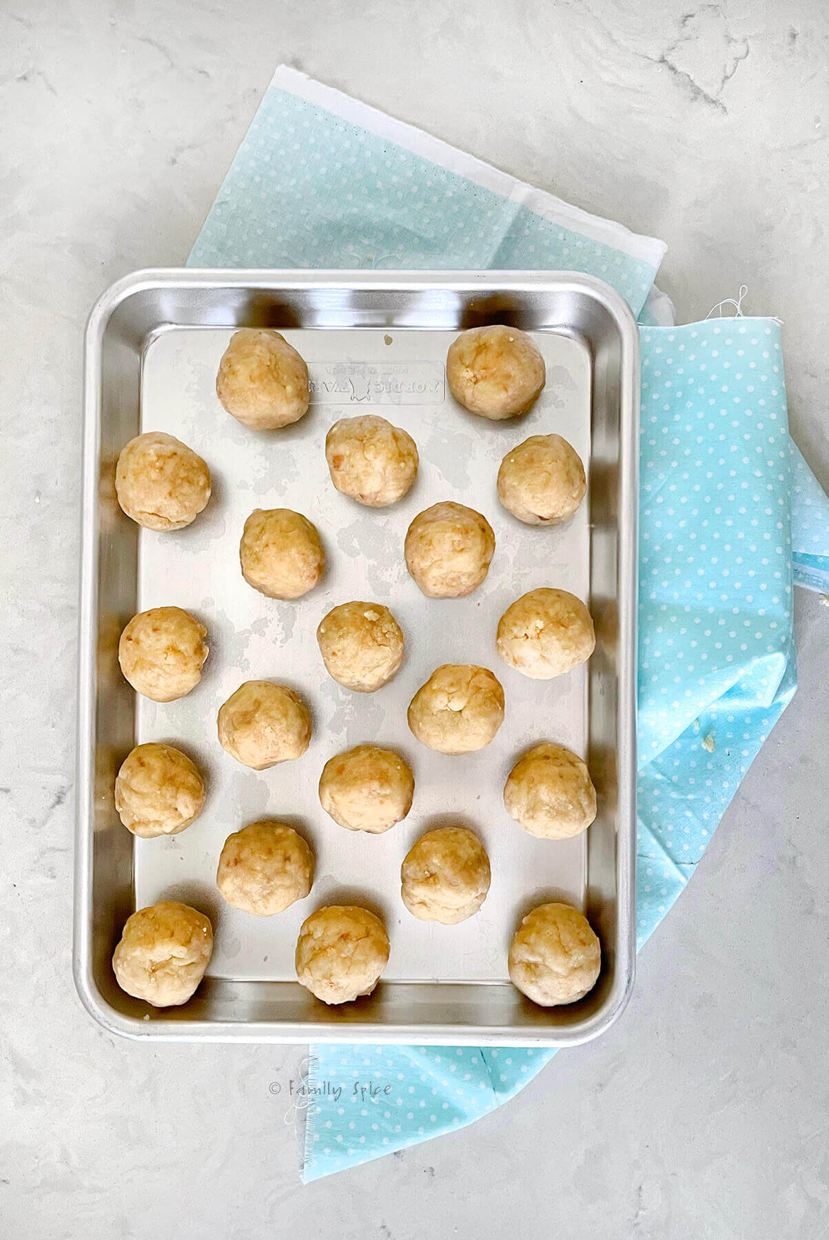 Vegan cake balls rolled and placed on a small baking sheet