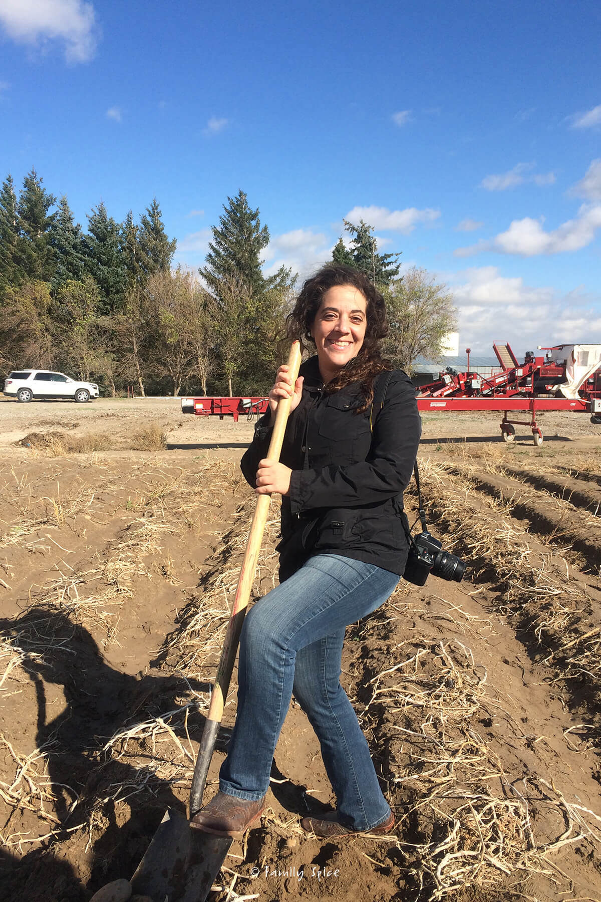 Laura Bashar in a potato field in Idaho with a shovel