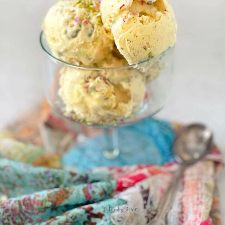 Side view of several scoops of Persian saffron ice cream (bastani) in a glass bowl