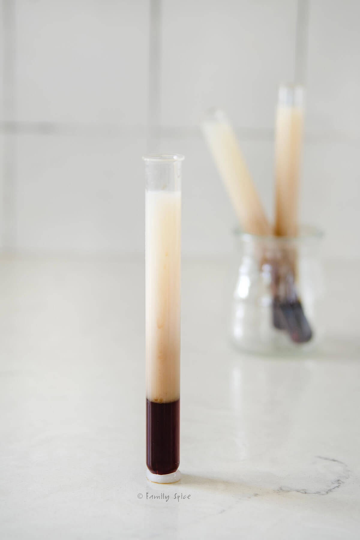 Closeup of a test tube that hold B52 drink, with two more behind it.