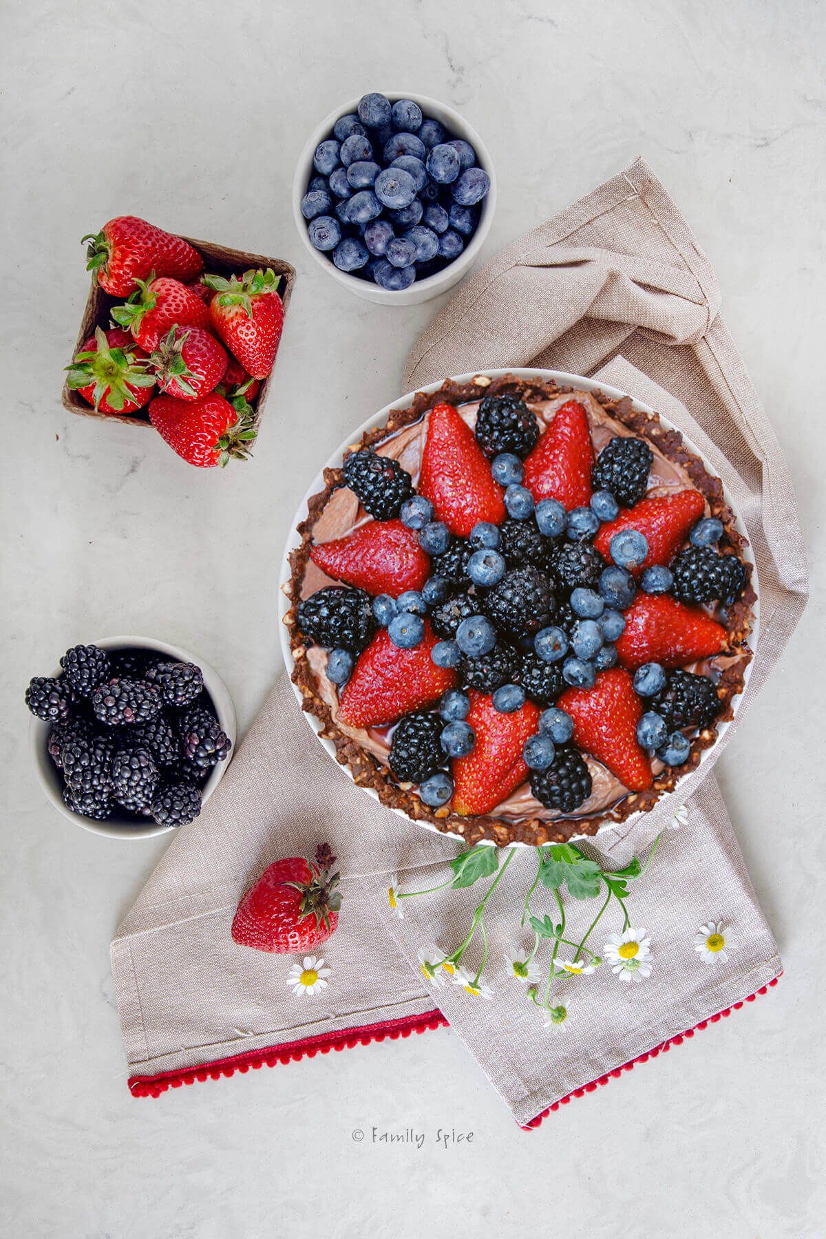 Top view of a nutella berry tart with fresh berries around it.